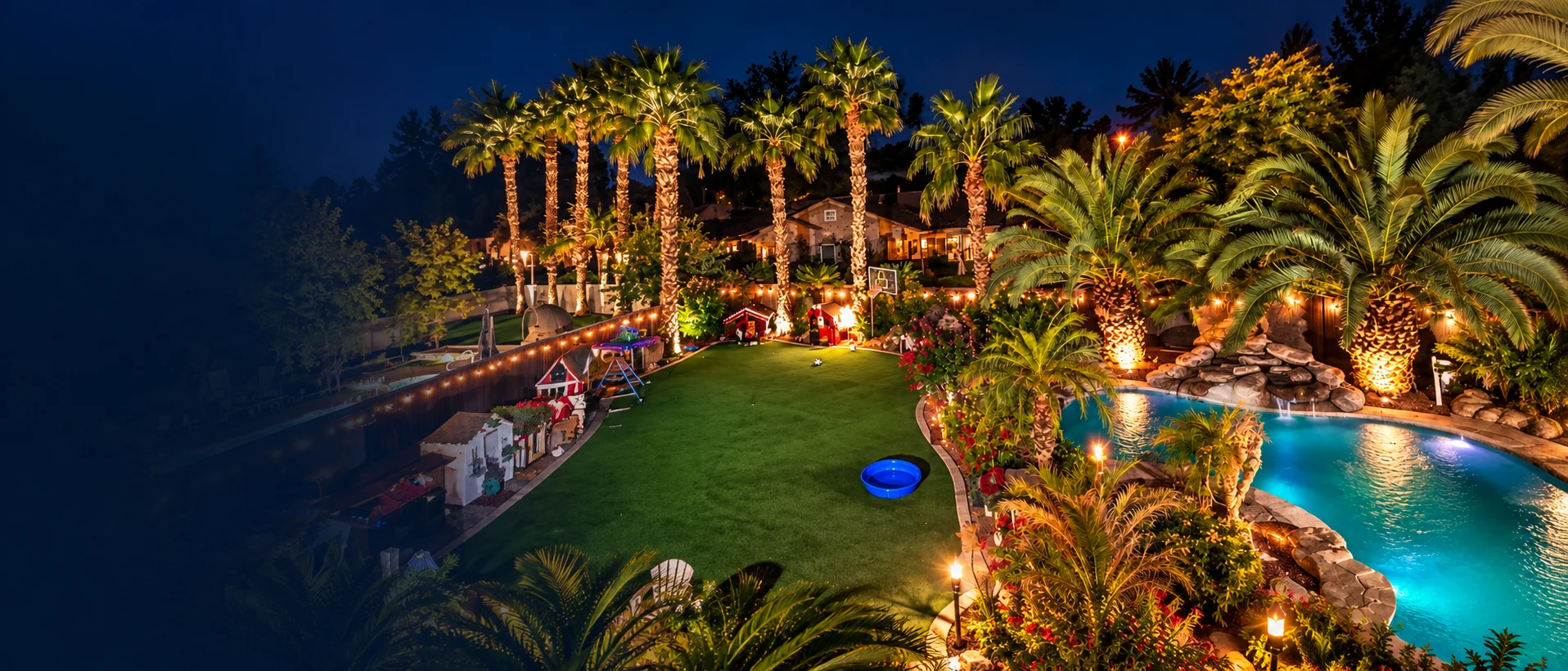 Barksville at night: the pool, open turf, palms and dog-house neighborhood